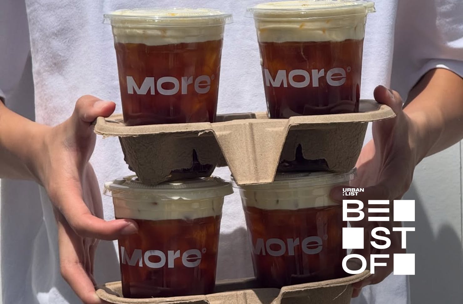 hands holding four montblancs in paper trays