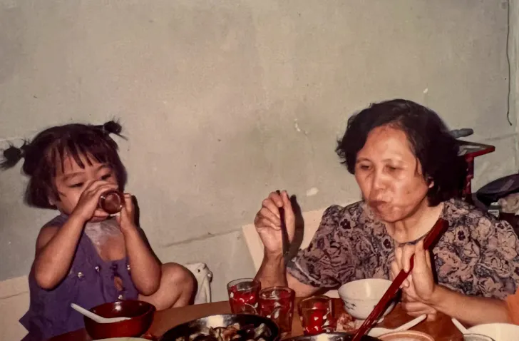 two people sitting at a table eating dumplings