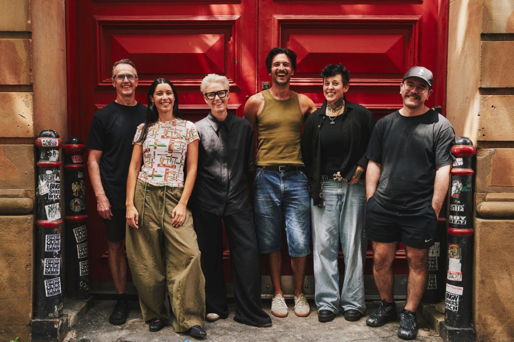 a group of people standing on the street smiling