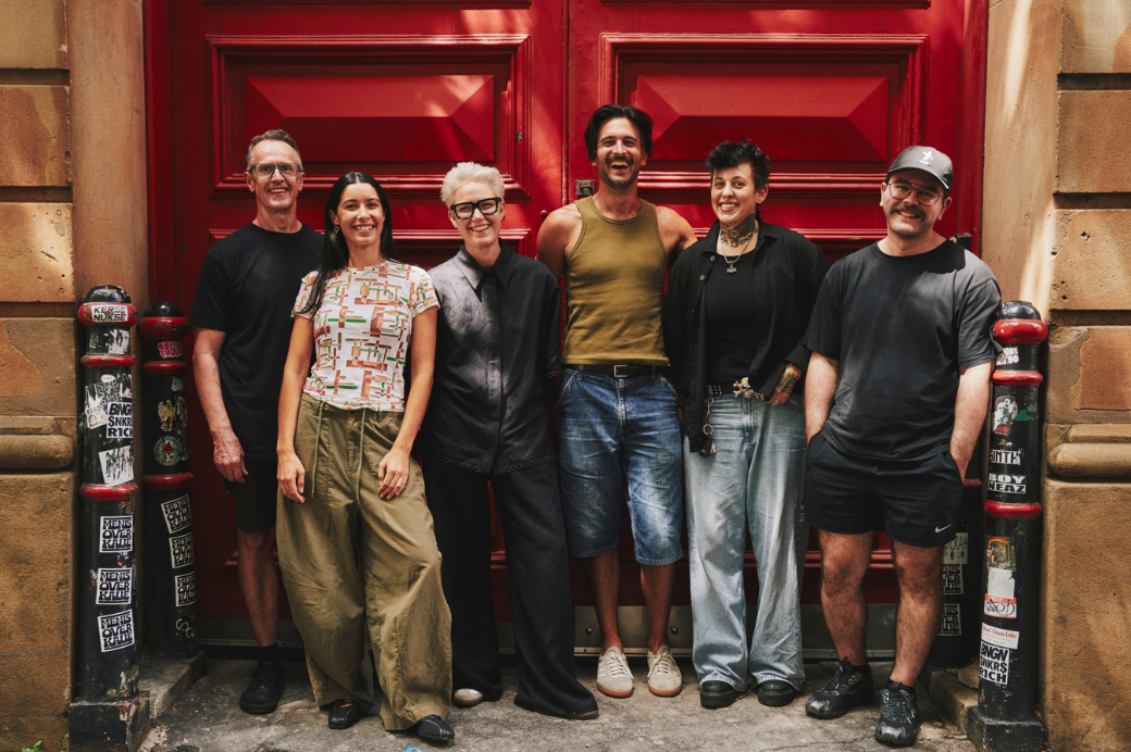 a group of people standing on the street smiling