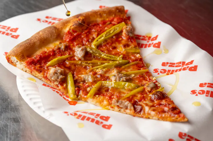 a slice of pizza on a piece of paper