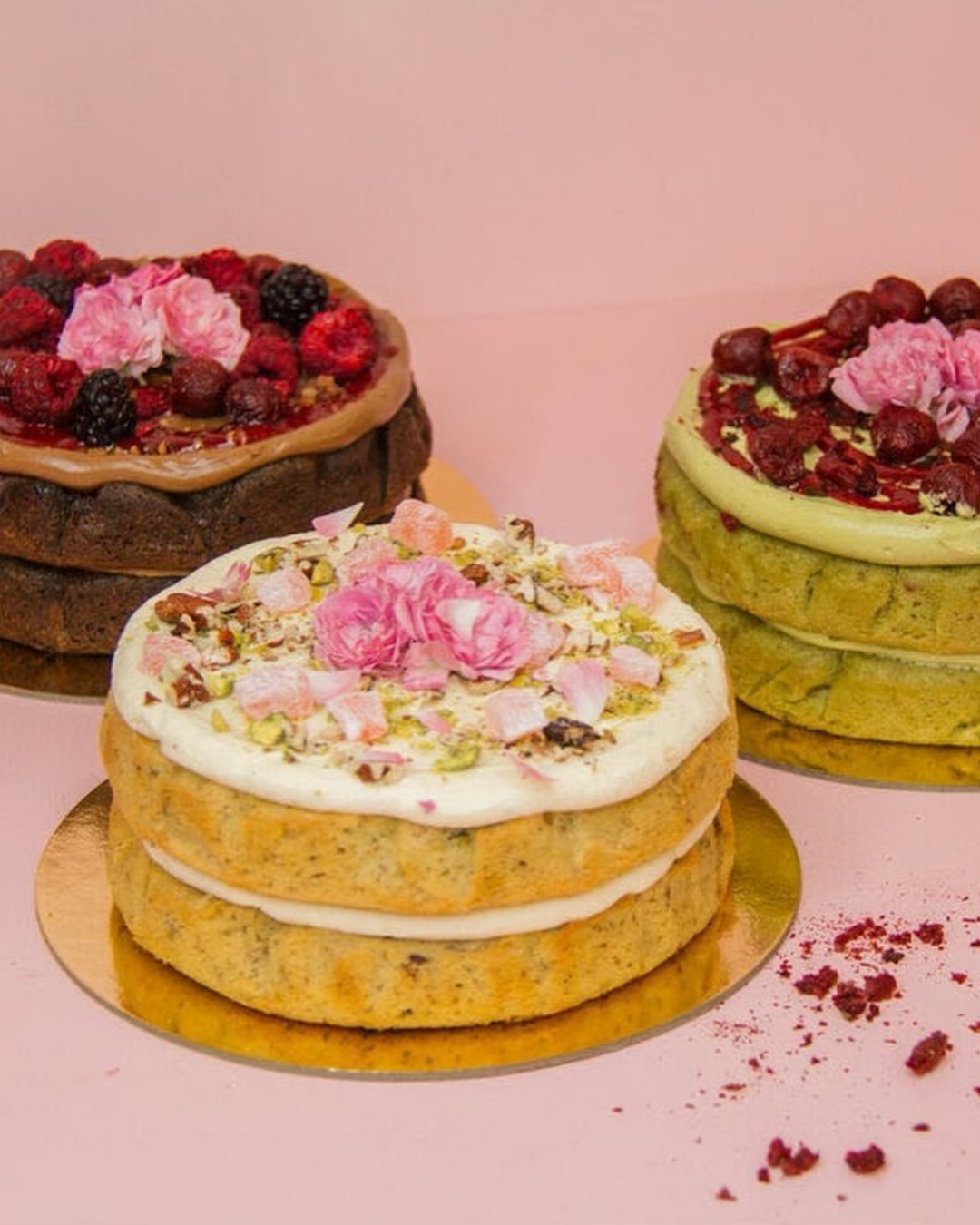 Three gorgeous cakes by The Caker on a pink background