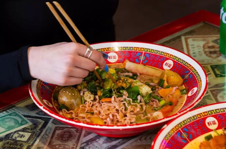 A person eating out of a colourful bowl with chopsticks at one of the best Box Hill restaurants called David's Master Pot