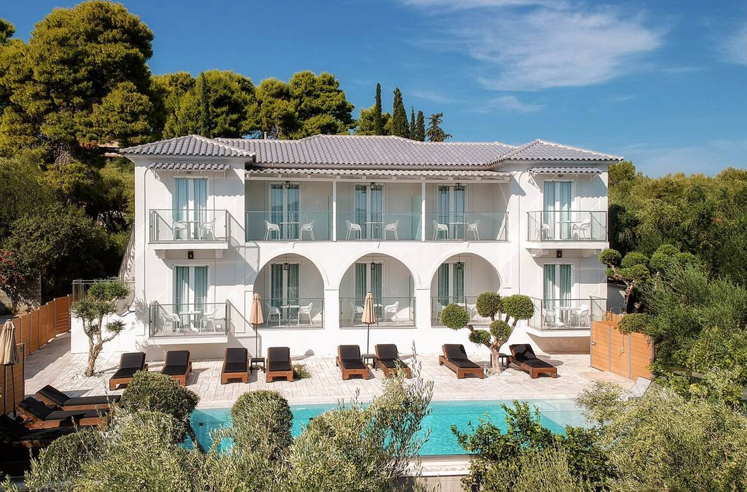 a white hotel building with an outdoor pool