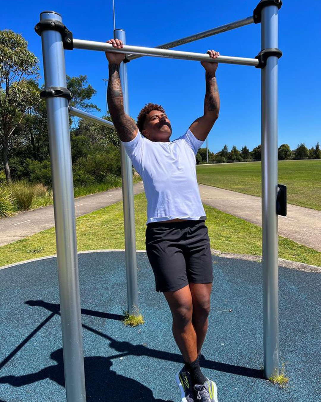 Ellia Green doing pull ups on park equipment