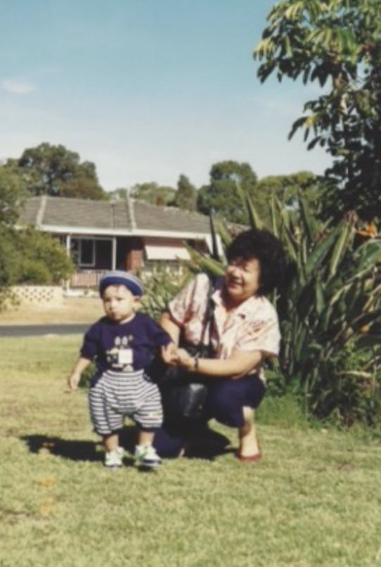 a grandmother and grandson on a front lawn