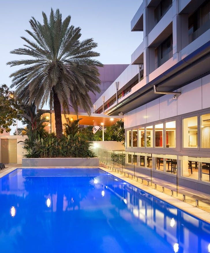 a pool next to the H on Smith Hotel at dusk