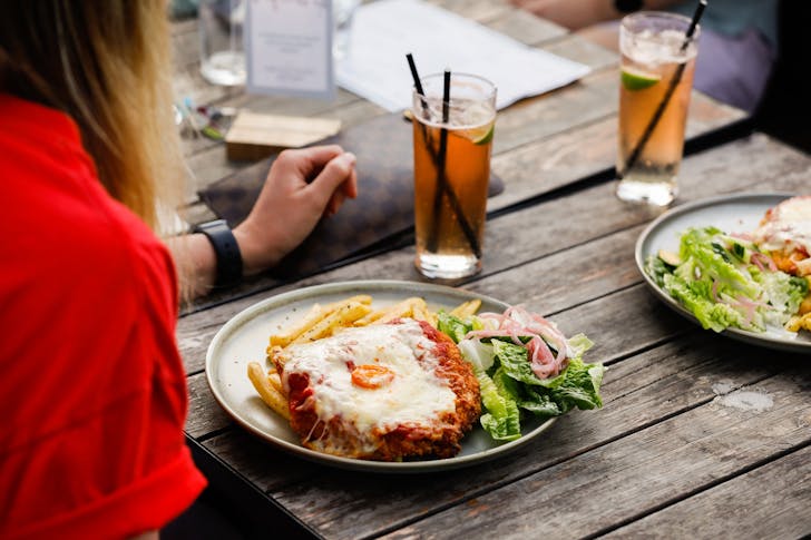 A person about to tuck into a best parma in Melbourne