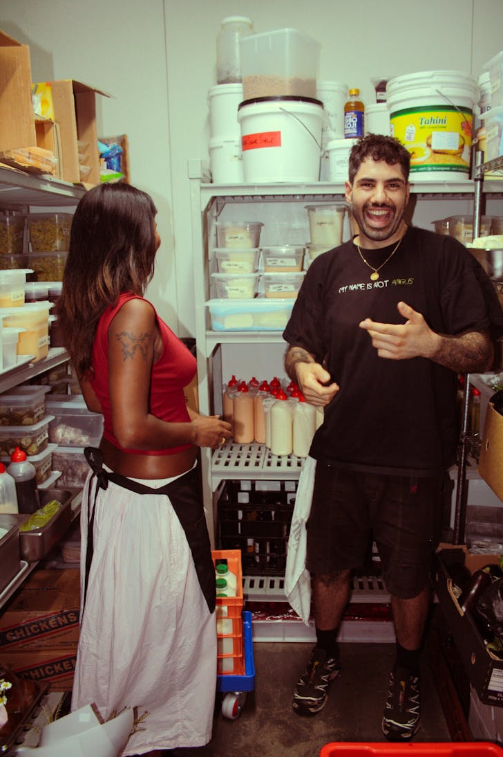 two people in a cool room, laughing and picking ingredients