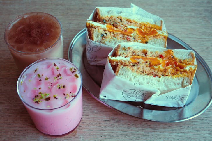 two drinks and a loaded sandwich on a table