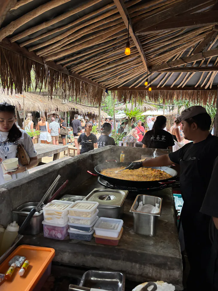 a person cooking paella at a market