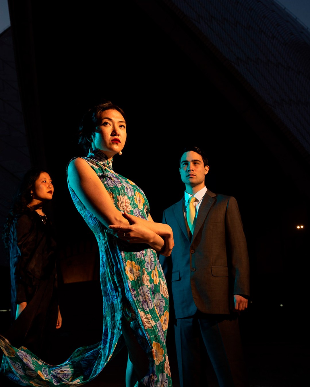 Three people stand in front of a black backdrop