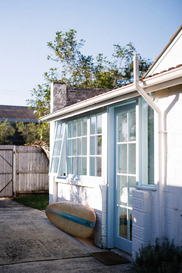 a cottage with a surfboard out the front