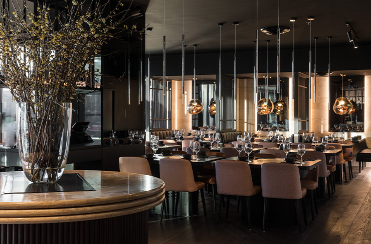 A light-filled dining room with wooden floorboards and low hanging light fixtures at one of the most sublime Box Hill restaurants called Katori