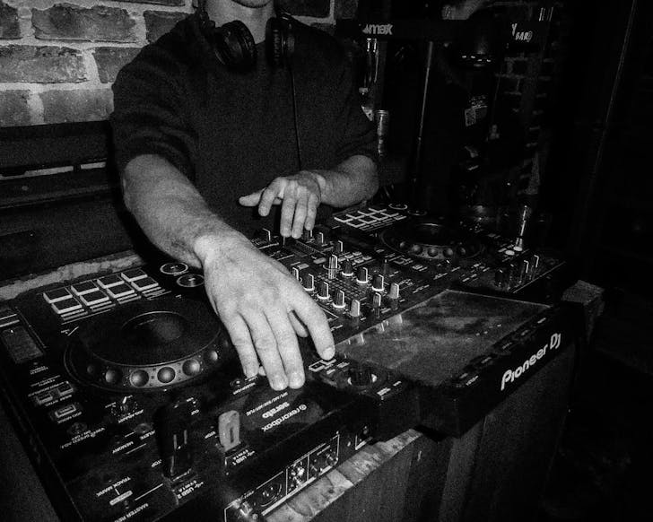 Black and white image of a male playing DJ decks