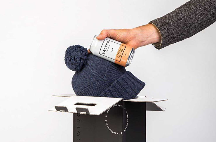 A person holding a can of Balter beer and navy-coloured beanie, from an alternative service to a flower delivery Melbourne