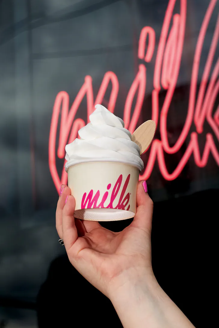 a hand holding a cup of soft serve