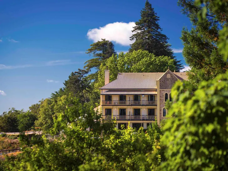 A view of Mount Lofty House surrounded by trees, one of the best romantic getaways in Australia
