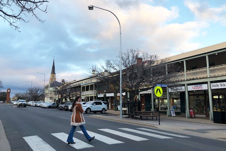 Woman walking across a crossing in the town of Mudgee.