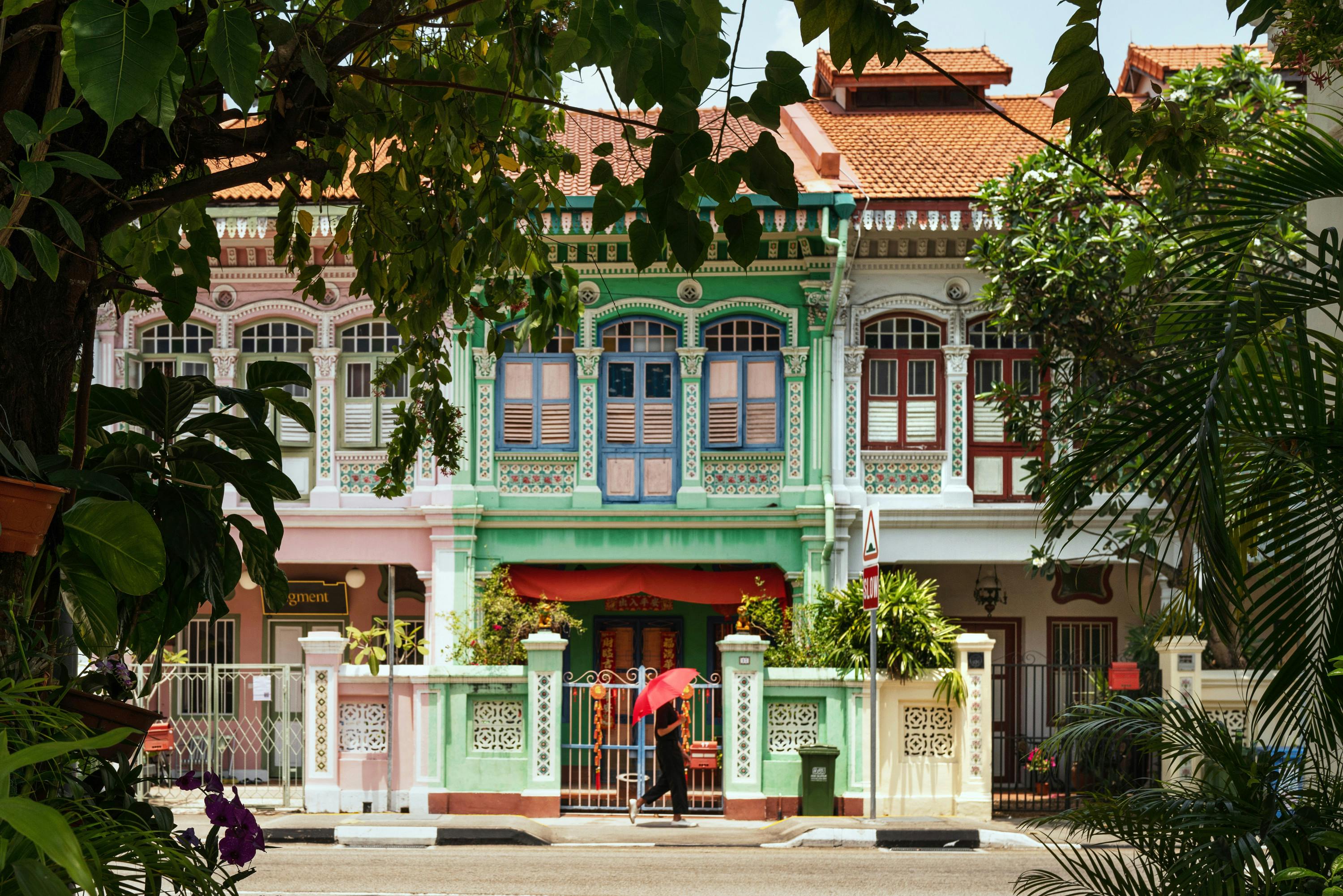 Shophouse in Singapore with a person walking past. 