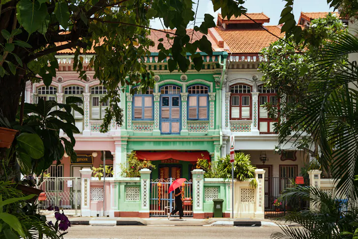 Shophouse in Singapore with a person walking past. 
