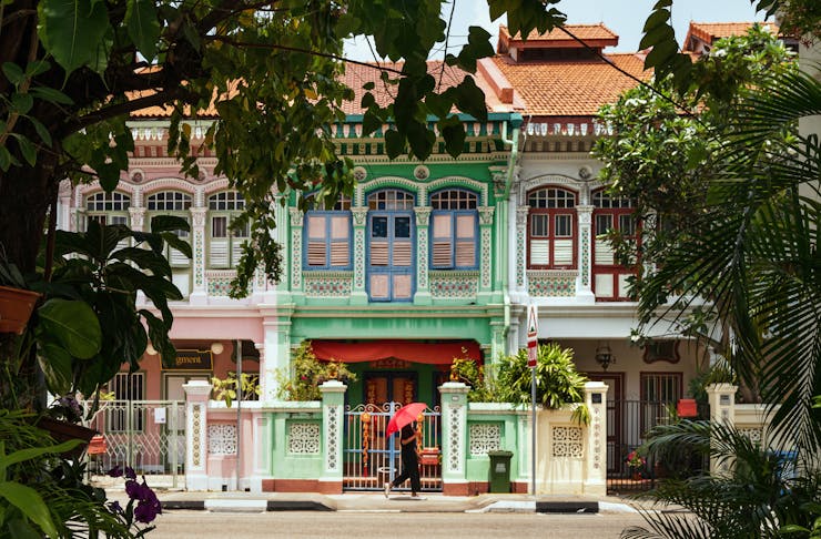 Shophouse in Singapore with a person walking past. 