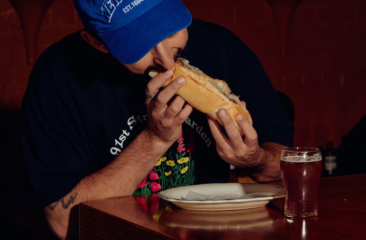 Person eating a sandwich at a Melbourne restaurant.
