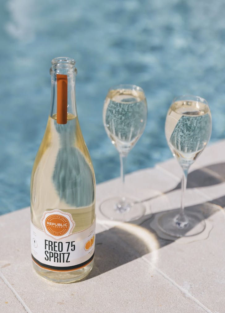 Bottle of the Freo 75 Spritz near a pool