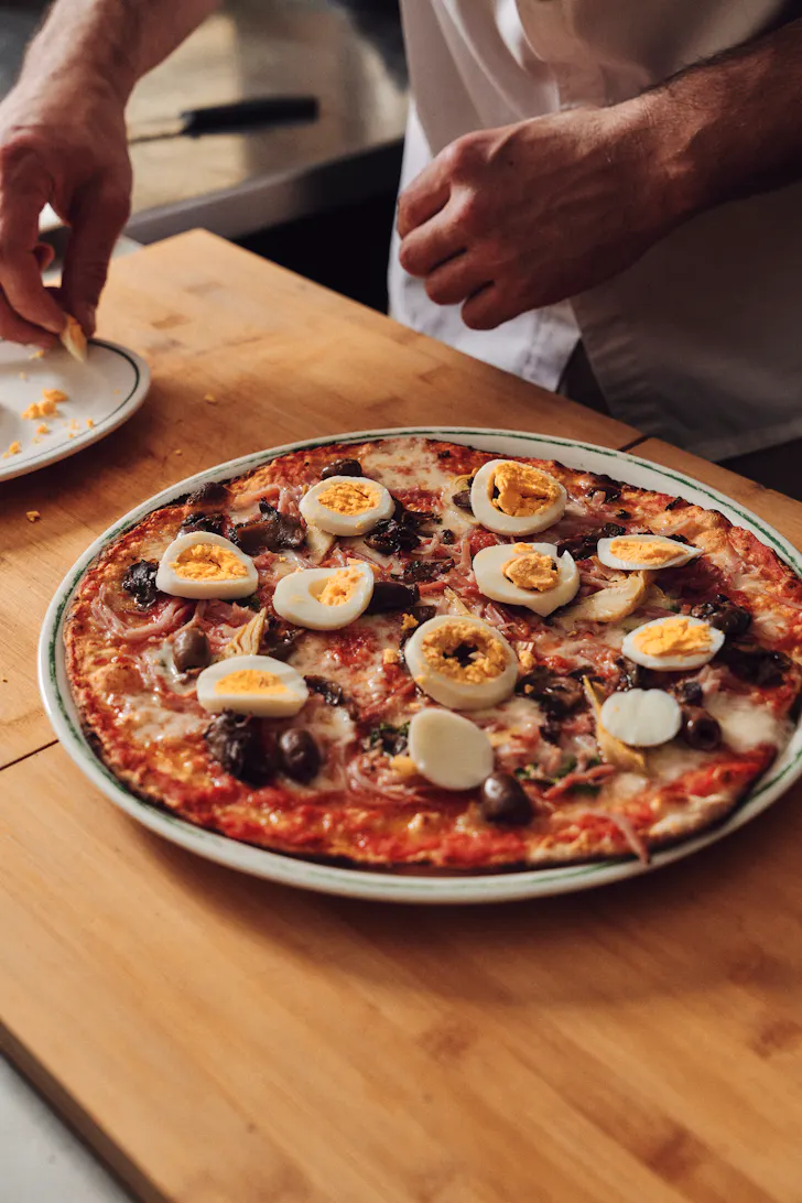 hands making a pizza