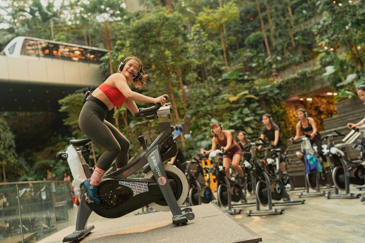 Woman leading a spin class outdoors.
