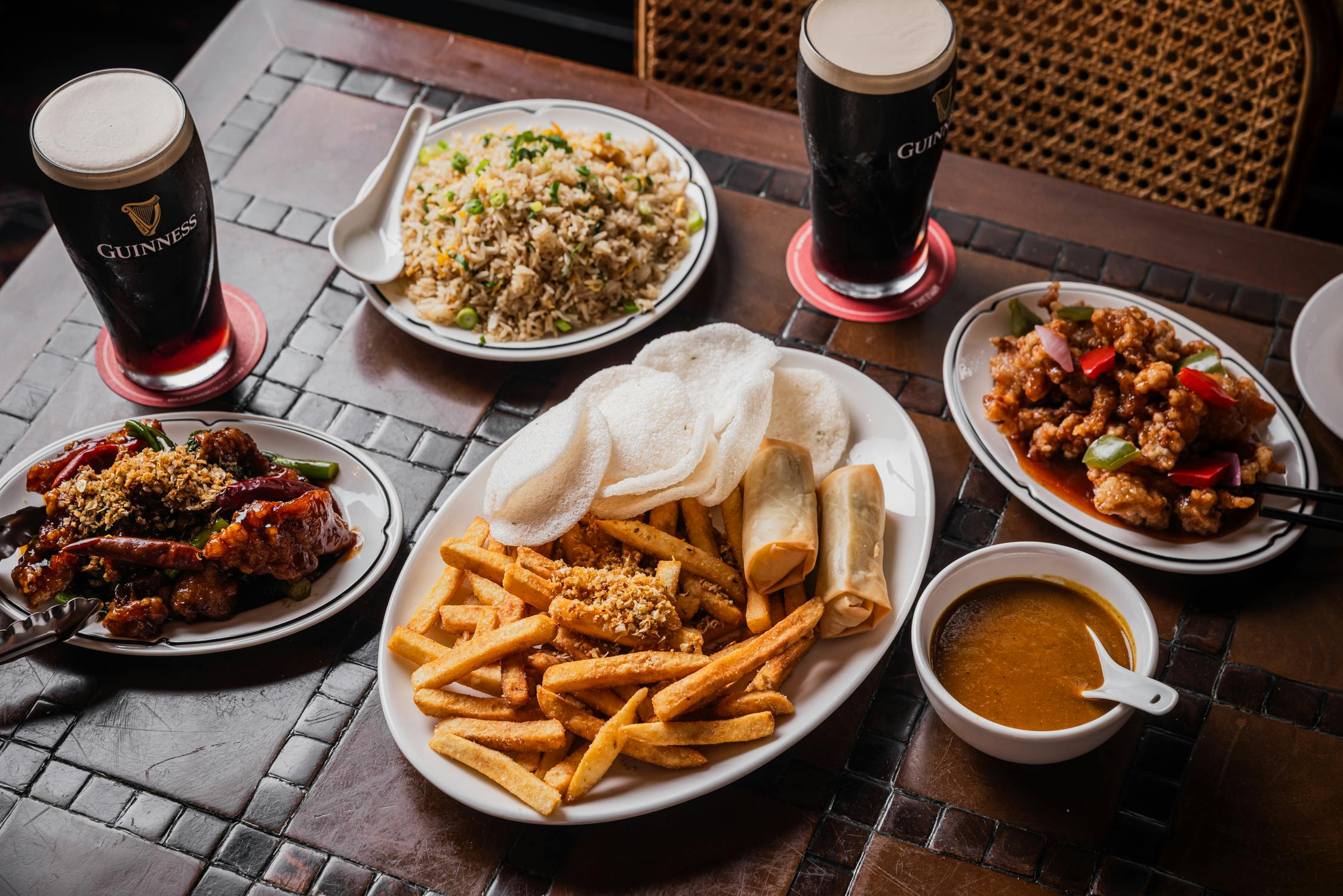 a banquet of spring rolls, guinness, fried rice and calamari
