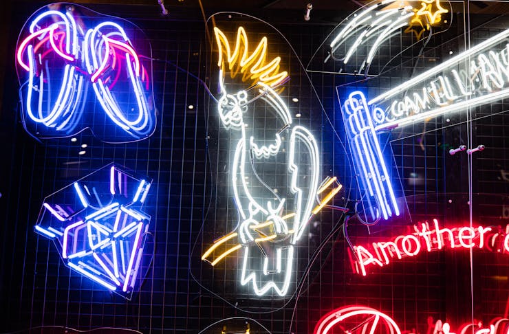 A close up shot of a bright neon wall complete with a neon cockatoo and a neon diamond.