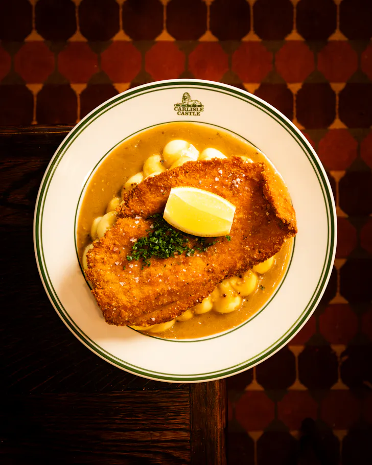 a chicken schnitzel on a bistro plate