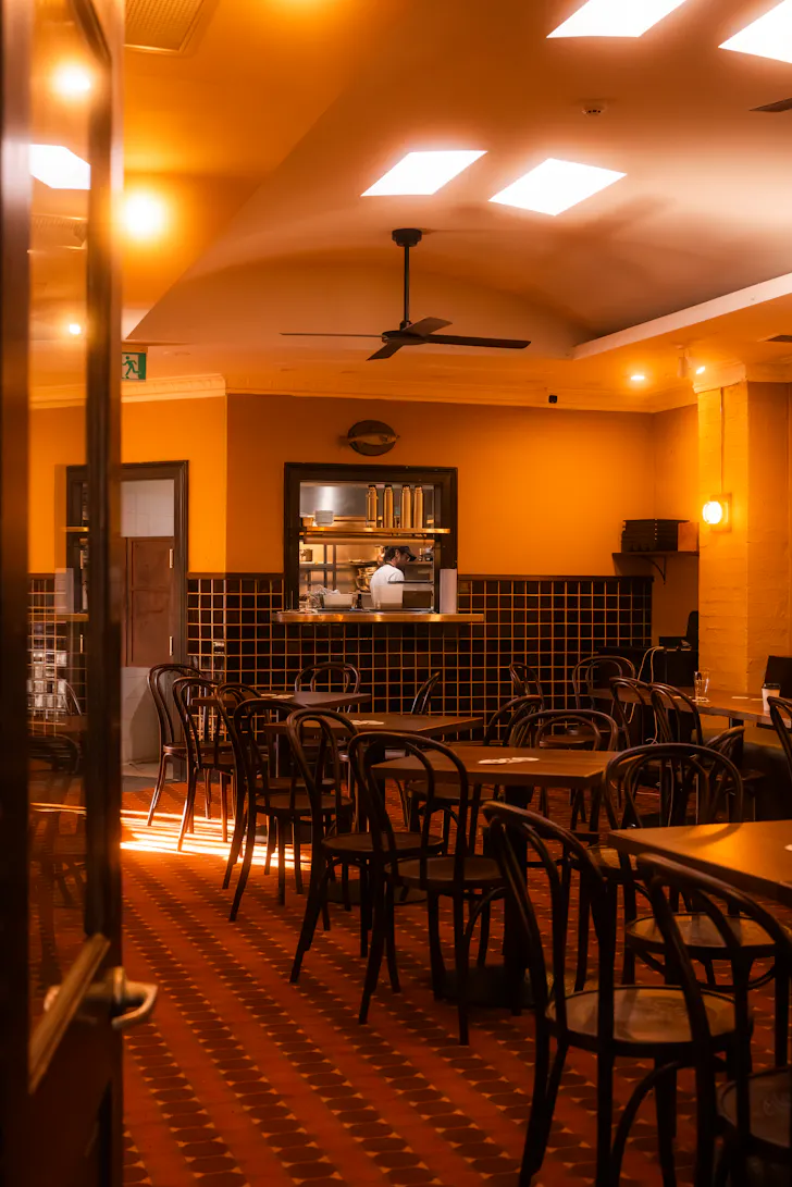bistro inside a pub with chairs and kitchen at the back
