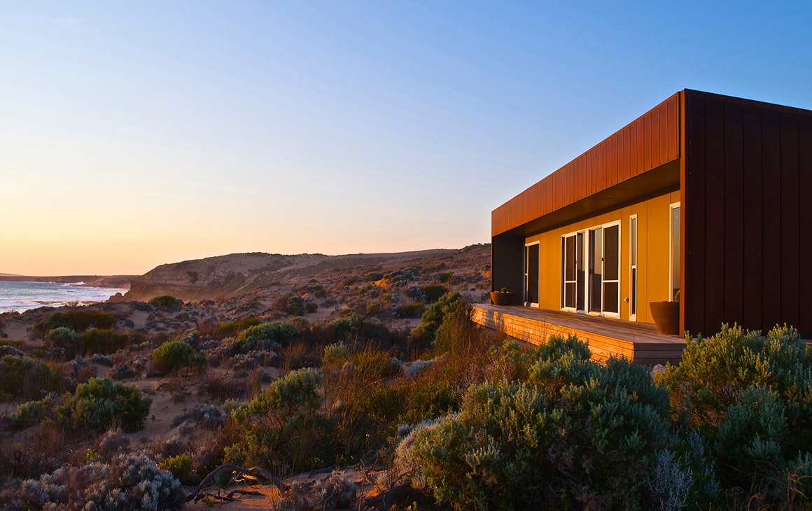 Camel Beach House sits nestled in the dunes, the beach in the distance.