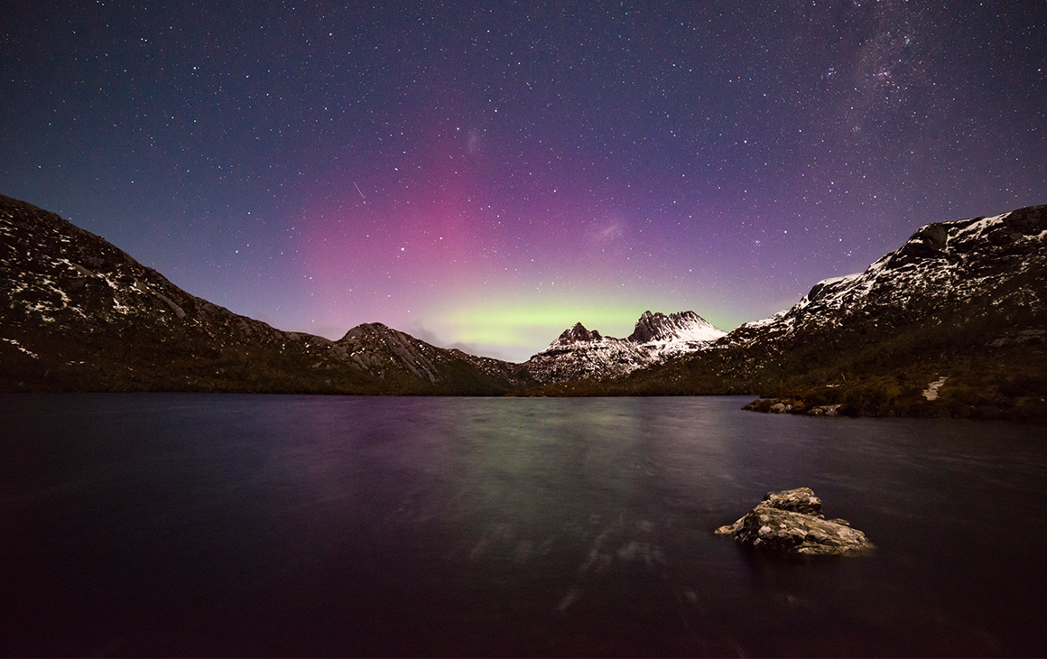the southern lights sparkle at night above a lake