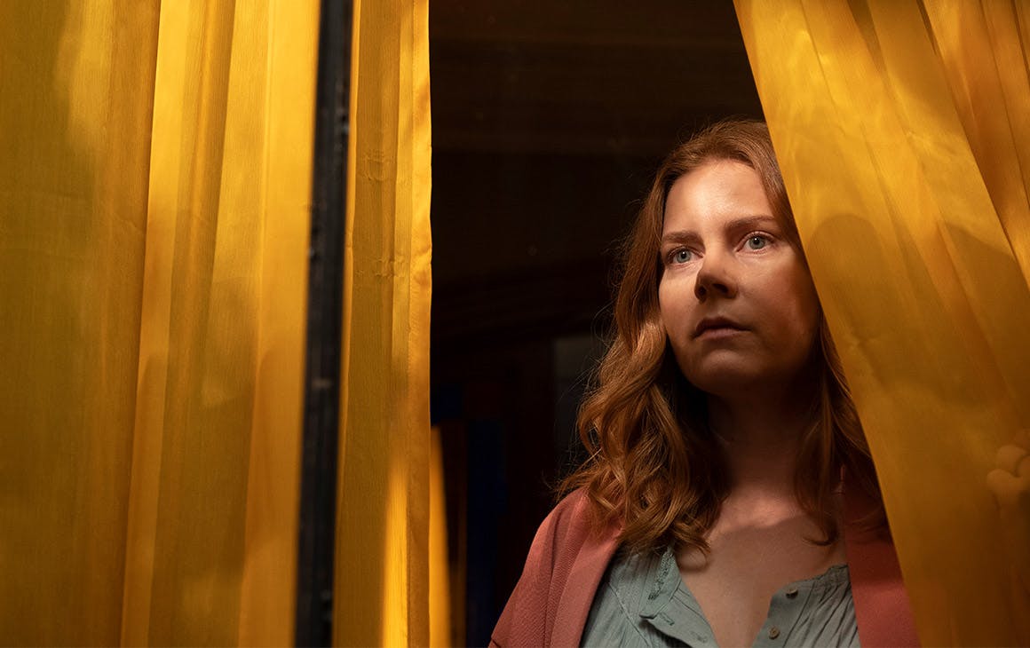 a woman stares out from a window.