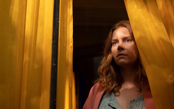 a woman stares out from a window.