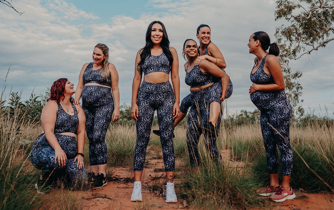 a group of women model activewear on red dirt in the bush of Western Australia