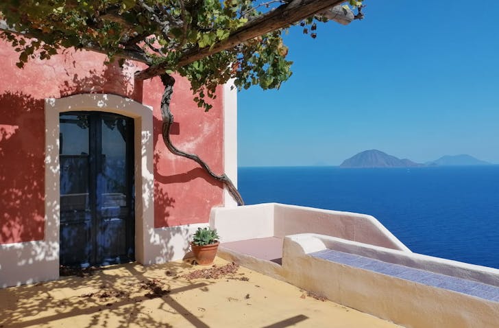 a pink building and vines overlooking an archipelago