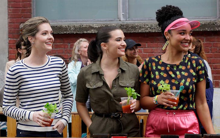 Aisha Dee, Katie Stevens and Meghann Fahy hold bloody marys while cheering on a race.