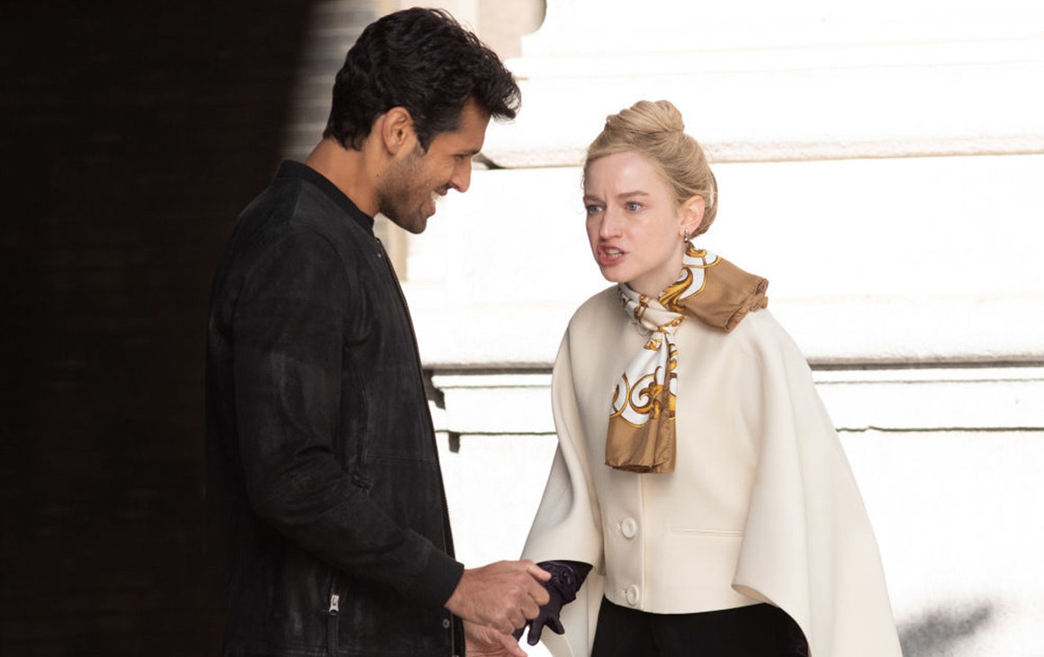 a young woman, dressed in a white coat, yells a man who has a smirk on his face