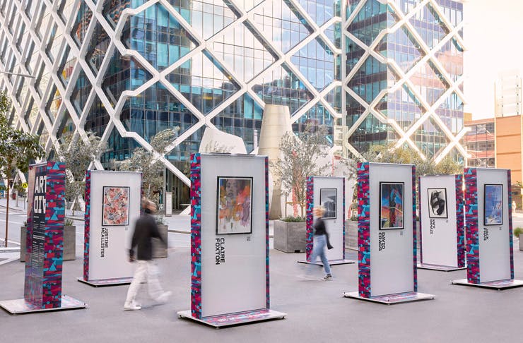 two people walking between outdoor art