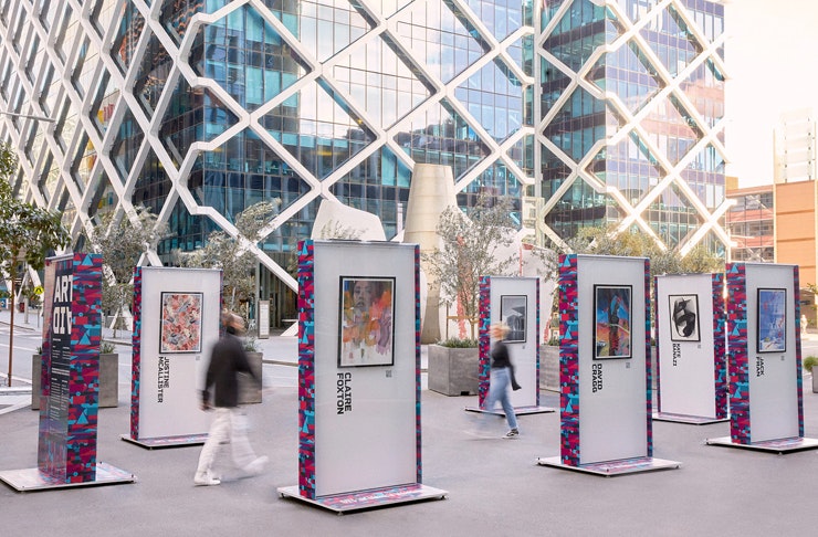 two people walking between outdoor art