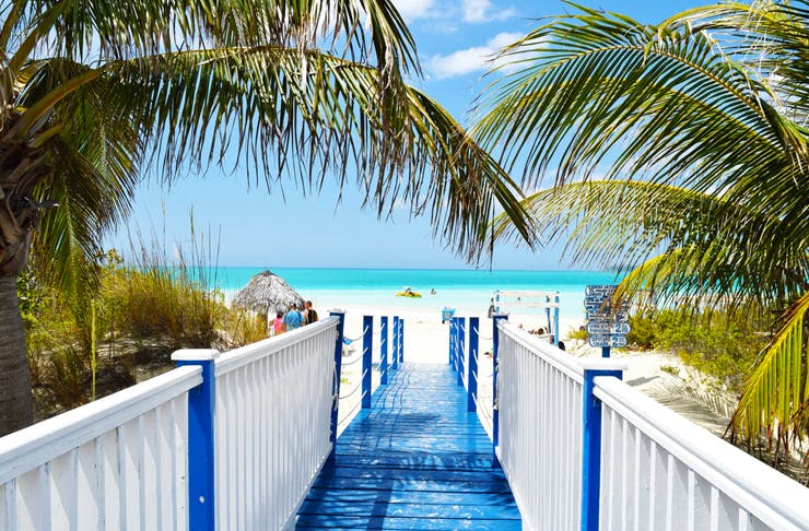 blue boardwalk leading to pristine clear beach in barbados