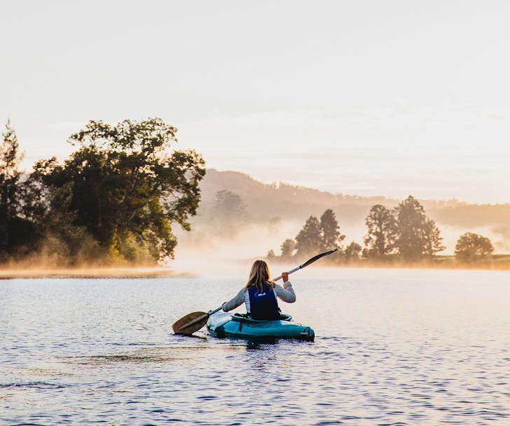 woman in kayak on misty river