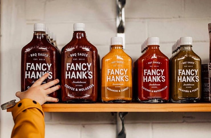 hand reaching for hot sauce on shelf