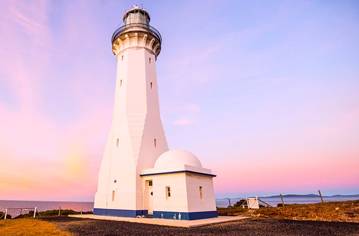sunset view of green cape lighthouses on headland