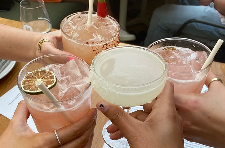 hands 'cheersing' with various margaritas