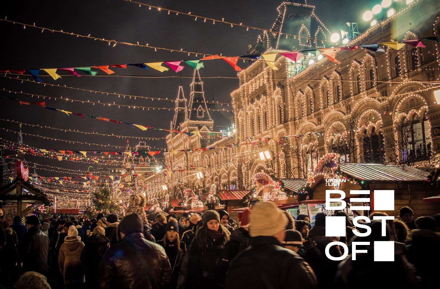 a crowd of people at a christmas market at night